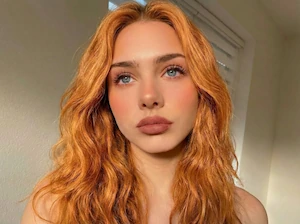 Ginger hair shade simulation: AI virtual hair dye test on wavy hair.