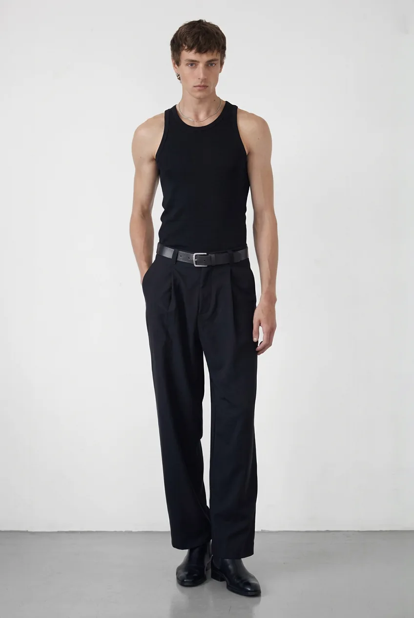 Caucasian male model in a black tank top and trousers, for try-on with the best AI outfit generator.