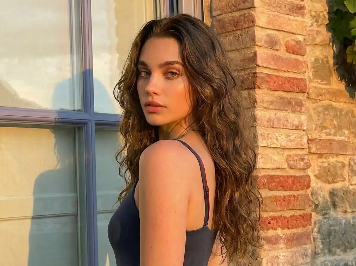 Sunlit portrait of a woman with long wavy brown hair displaying her best hair color based on color analysis.