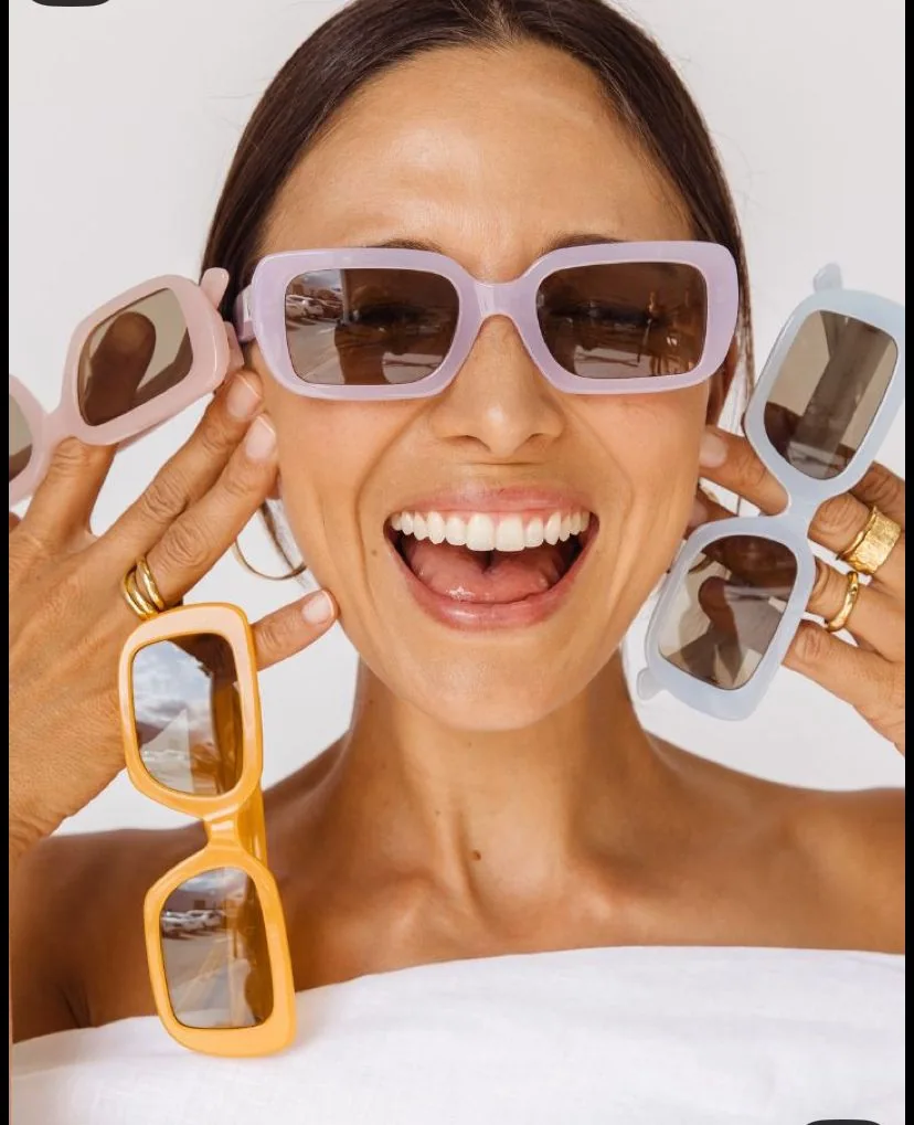 Smiling woman holding colorful frames to share her AR glasses look for feedback.